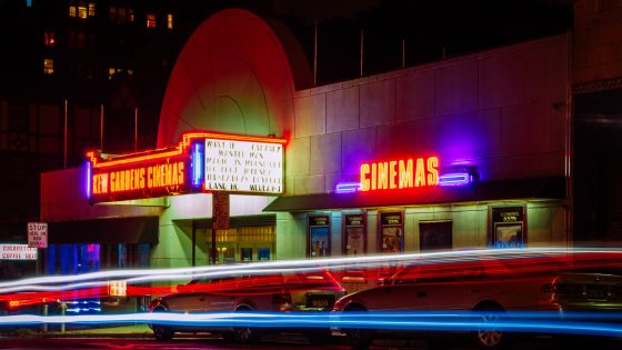 time lapse photography of car lights in front of cinema